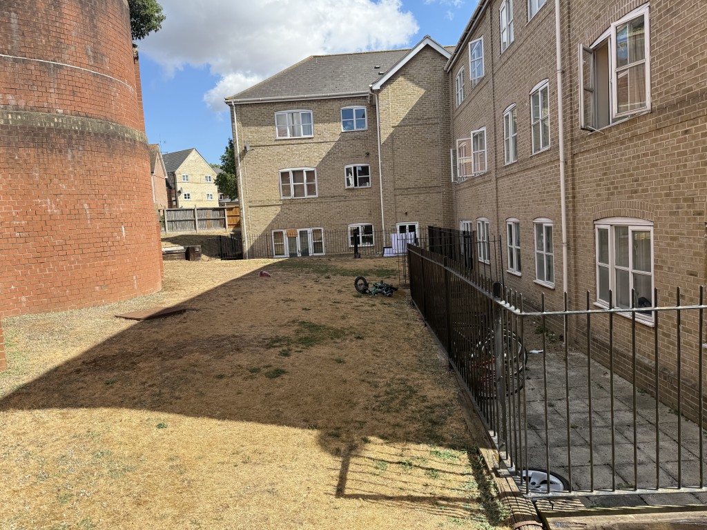Lot: 36 - TWO-BEDROOM FIRST FLOOR FLAT FOR IMPROVEMENT - Shot of communal gardens showing back of building